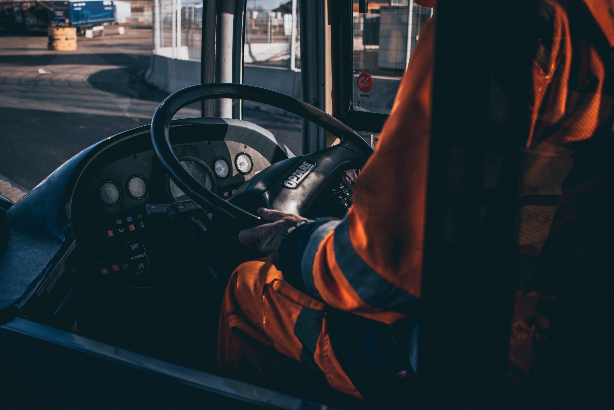 pexels photo 4200122 4200122 Bus driver operating vehicle from the cockpit in an industrial setting, showcasing control and focus.
