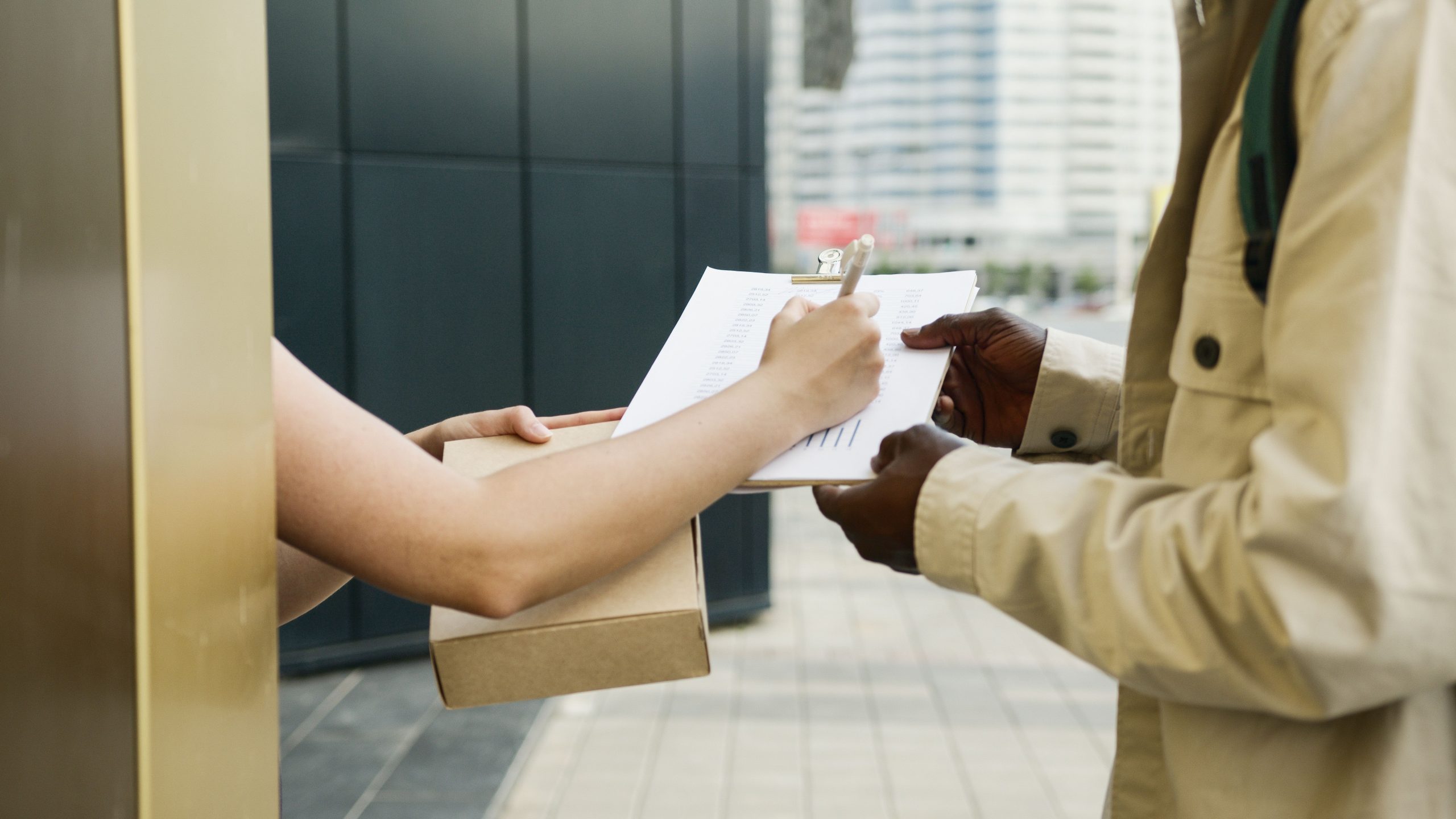 pexels photo 8989470 8989470 An outdoor scene of a package being delivered and a receipt being signed.